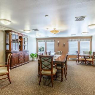 A spacious dining room with elegant furnishings and ample natural light.