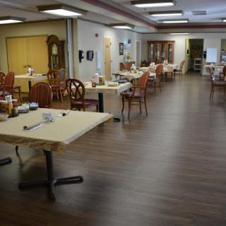 A spacious dining area featuring neatly arranged tables and chairs, with a warm and inviting ambiance.