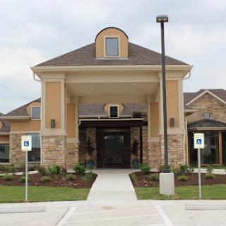 The inviting entrance of a modern residential facility surrounded by well-maintained landscaping.