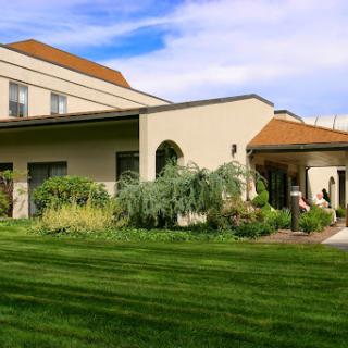 A well-maintained building surrounded by lush greenery and a manicured lawn.