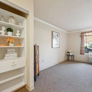 Cozy living room with decorative shelving and a bright window.