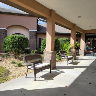 An outdoor view of a building entrance with benches and landscaping.