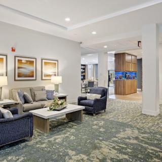 A modern living room with comfortable seating, decorative artwork, and warm lighting.