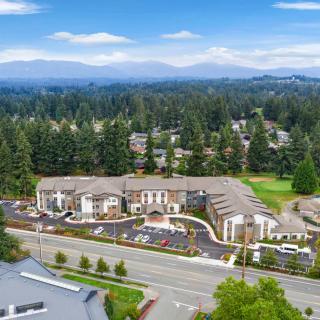 Aerial view of a large building complex surrounded by trees and mountains.