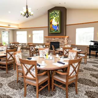 A cozy dining area featuring wooden tables and chairs, adorned with a beautiful stained glass window, perfect for meals and gatherings.