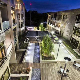 Modern apartment complex courtyard illuminated at night.