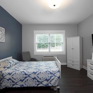 A cozy modern bedroom featuring a blue accent wall and stylish furnishings.