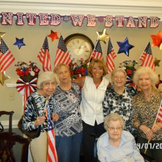 A group of people celebrating with American flags against a decorated backdrop.