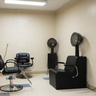 An empty hair salon with styling chairs and hair dryers.