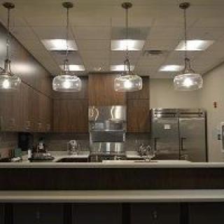 A modern kitchen with pendant lighting and stainless steel appliances.
