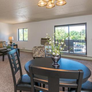 A spacious living and dining area with modern furniture and plenty of natural light.