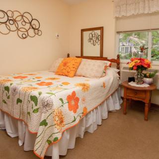 A cozy bedroom with floral-themed bedding and decorations.