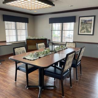 A well-lit conference room featuring a large table surrounded by chairs, perfect for meetings and discussions.