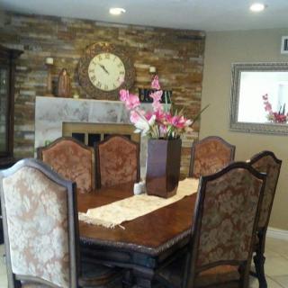Elegant dining room with a wooden table set, fireplace, and floral centerpiece.