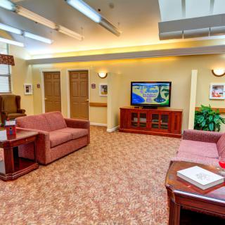 A cozy lobby area with sofas and a television, featuring warm lighting and decorative elements.