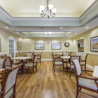 A well-lit dining area with wooden floors and elegant seating arrangements.