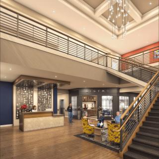 A modern lobby interior featuring a staircase, reception desk, and stylish furniture.