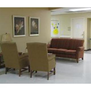 A cozy waiting room with comfortable chairs and a sofa.
