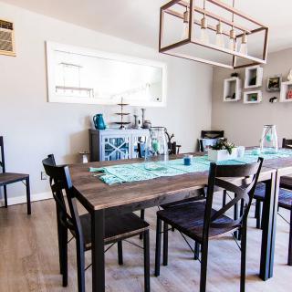 A modern dining room with a wooden table and decorative elements.