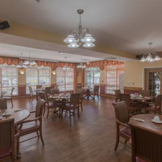 A cozy dining area with elegant chandeliers and natural lighting.