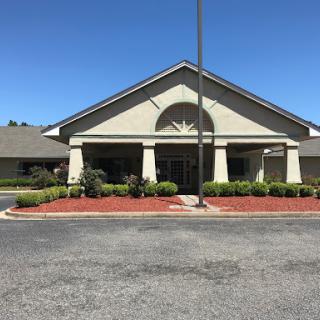 A well-maintained building with a welcoming entrance and landscaped surroundings under a clear blue sky.