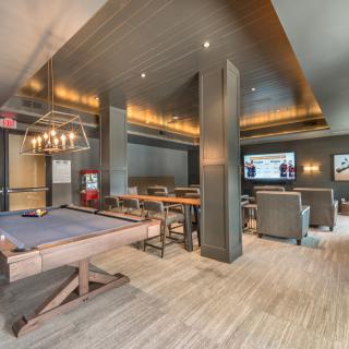 A luxurious lounge featuring a pool table, comfortable seating, and a large television.