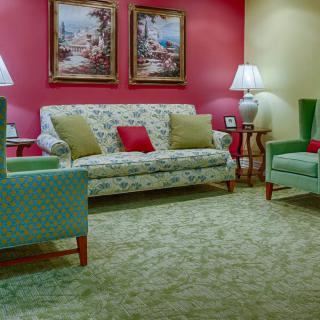 A cozy living room with floral-patterned furniture and colorful walls.