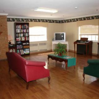 A cozy living room with sofas, a television, and a bookshelf on a wooden floor.