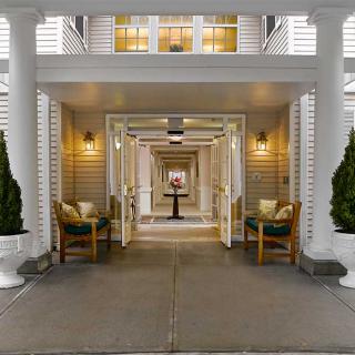 Elegant building entrance with pillars and seating area.