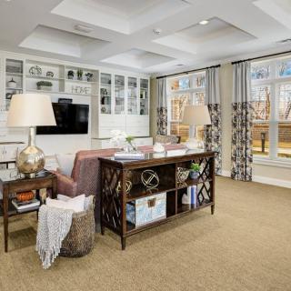 A modern and cozy living room featuring a stylish sofa, decorative shelves, and contemporary lighting.