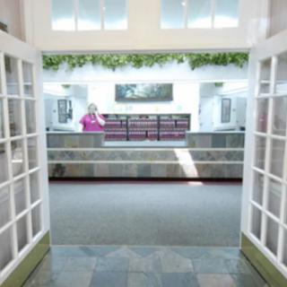 A spacious entrance with glass doors leading to a reception area.