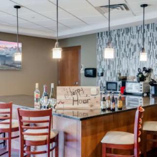 Modern bar interior with hanging lights and a selection of bottles on the counter.