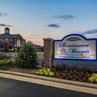 The entrance to Renaissance Marquis, showcasing its welcoming sign and beautifully landscaped surroundings during sunset.