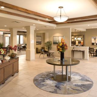 A spacious and elegantly decorated lobby featuring modern furniture and warm lighting.