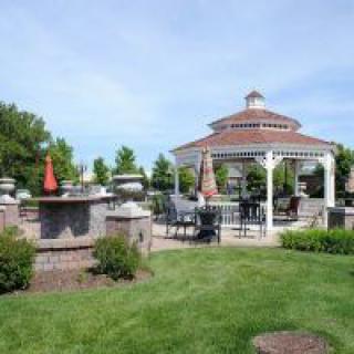 A beautiful garden featuring a gazebo and outdoor seating area surrounded by lush greenery.