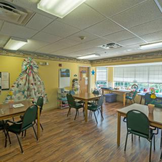 A cozy dining area with tables, chairs, and decorative elements on the walls.