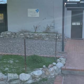 Entrance to a building with a landscaped area and signage.