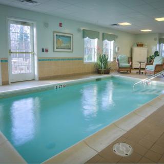 An inviting indoor swimming pool with seating and decor, perfect for relaxation and leisure.