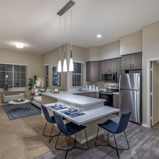 A modern open-concept kitchen and dining area with sleek appliances and contemporary furniture.
