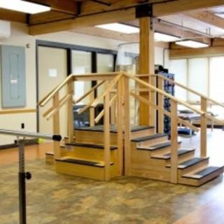 An indoor physical therapy room with a staircase setup for rehabilitation exercises.