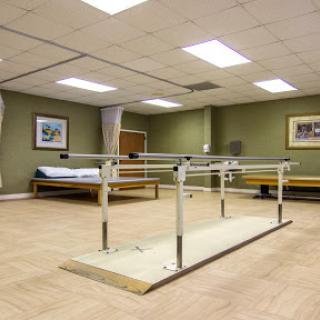 A physical therapy room featuring parallel bars designed for rehabilitation exercises.