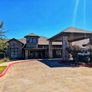 A modern residential building with a welcoming entrance under clear blue skies.