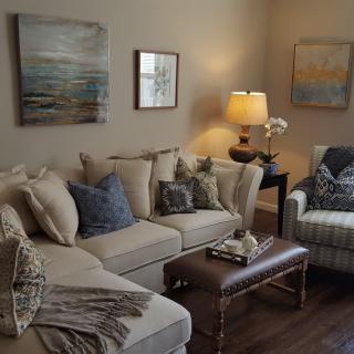 A cozy living room with a sofa, armchair, and decorative wall art.