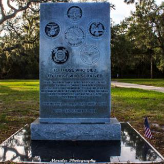 A memorial stone dedicated to honoring individuals, featuring engraved illustrations and text.