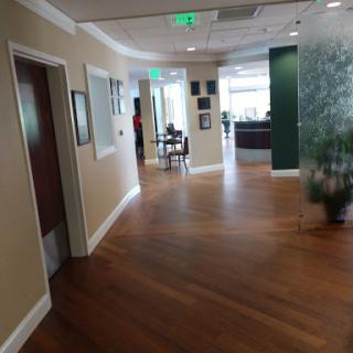 A view of a modern office hallway with wooden flooring and contemporary decor.