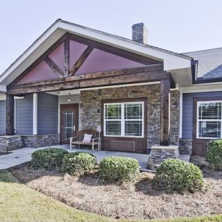 A modern house with a stone facade and neatly landscaped front yard.
