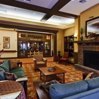 A cozy living room with multiple sofas, a fireplace, and warm lighting.