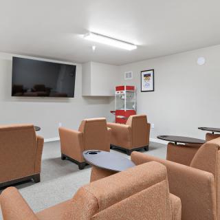 A cozy recreation room with comfortable seating and a large television, perfect for movie nights.