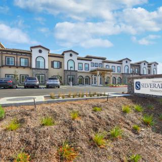 A stylish hotel building with modern architecture and well-maintained landscaping under a partly cloudy sky.