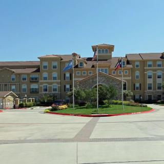 A large hotel building with multiple flags at the entrance.